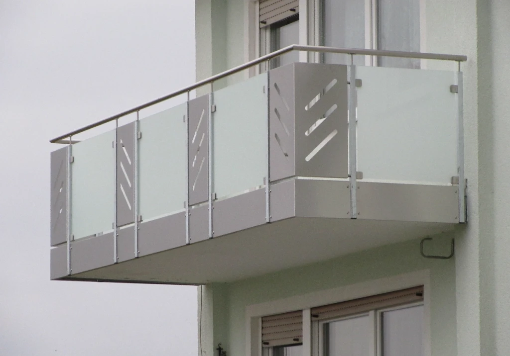 Balkon mit Edelstahlgeländer und satinierten Glasfüllungen an einem Wohnhaus