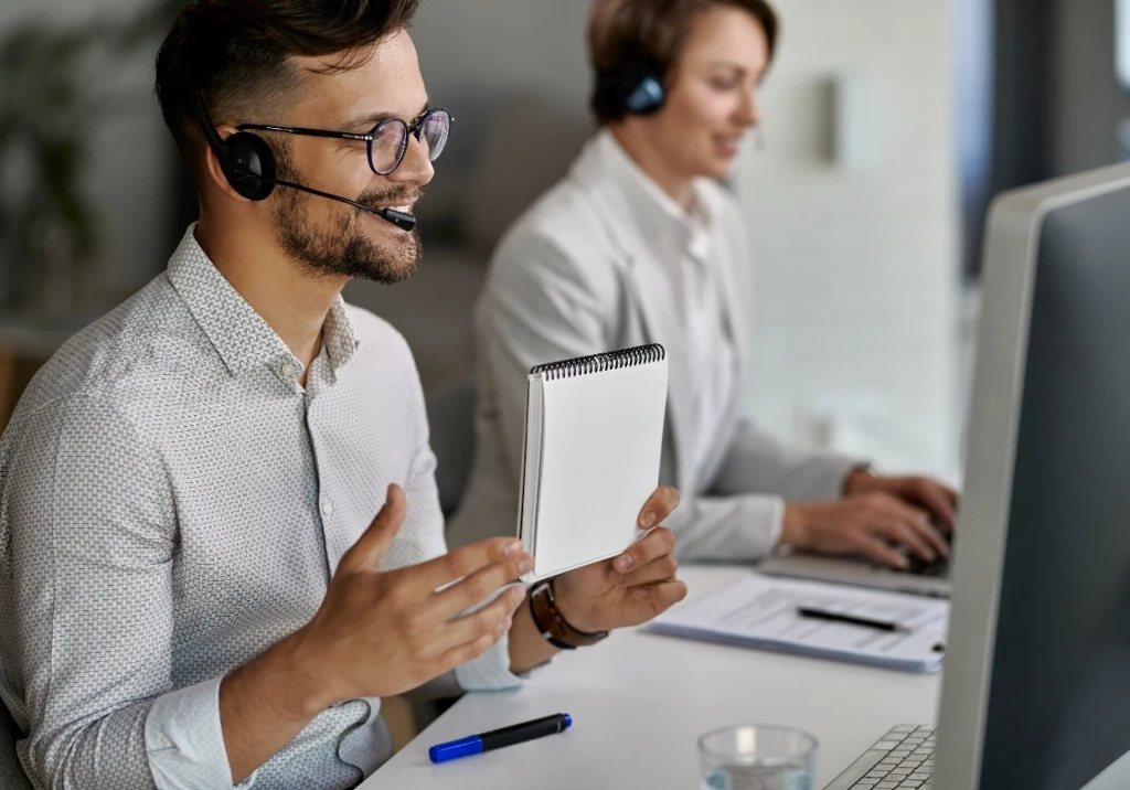 Kundenberater mit Headset im Büro während eines Beratungsgesprächs